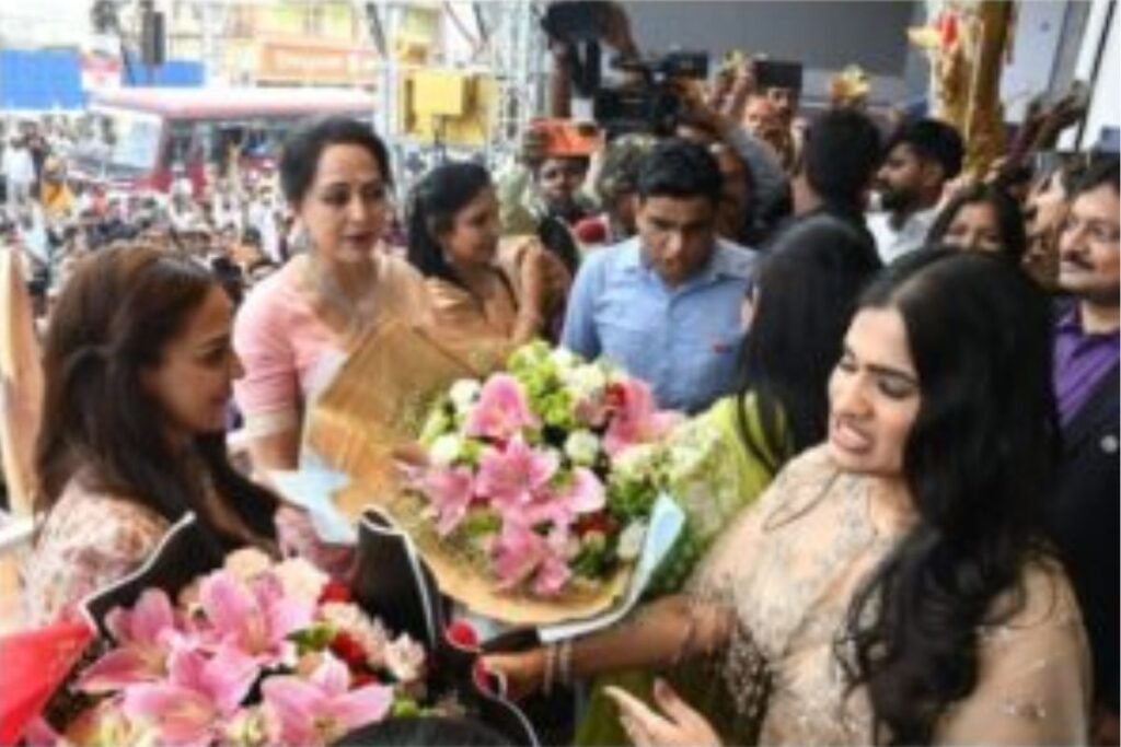 Hema Malini and Esha Deol wave to a large crowd of fans during the showroom inauguration in Ranchi, showcasing their star power and popularity.