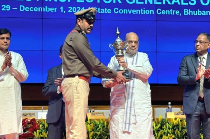 Union Home Minister Amit Shah presenting the Best Police Station Award to Nimiyaghat Station In-charge Rana Jung Bahadur in Bhubaneswar, 2024.