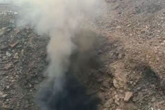 Image showing flames and toxic gas emissions from cracked earth in Dhanbad, causing alarm among local residents.