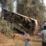 Overturned bus in Ramgarh with onlookers and emergency responders at the accident scene.