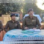 Massive seizure of illegal liquor by Koderma police with vehicles and cartons displayed, highlighting the successful operation against smuggling.