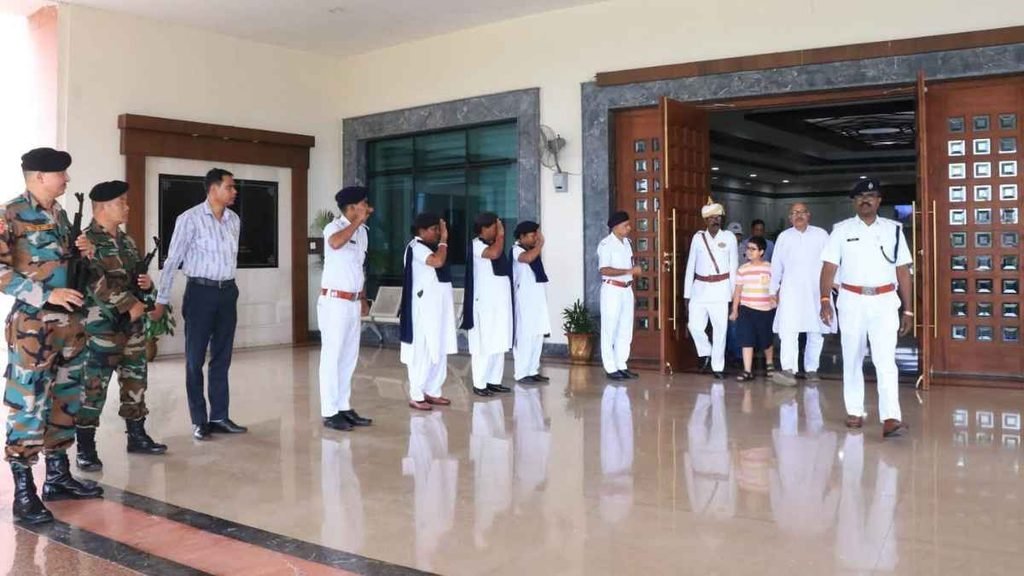 A child accompanied by adults and uniformed personnel inside a public building