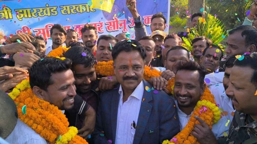 Political gathering with a leader surrounded by supporters wearing marigold garlands